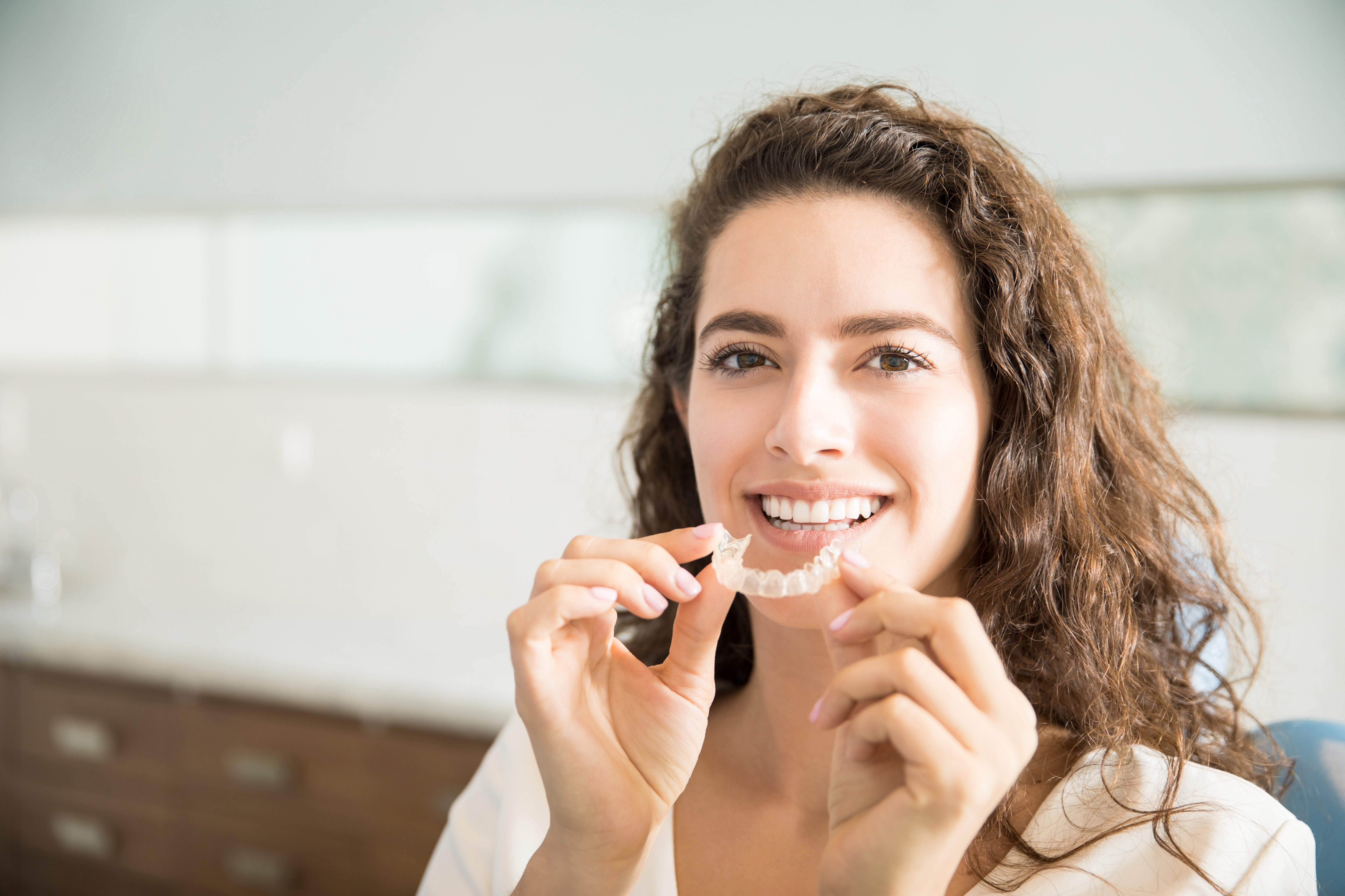 portrait-beautiful-patient-holding-orthodontic-retainers-dental-clinic